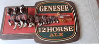 Full view of the Genesee 12 Horse Ale plastic wall sign showing the horses and wagon depicted in 3D on the sign
