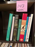 Photo of eight bird-related books on a shelf with a sticky note labeled '143 Birds'.