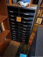 Front view of the wooden literature organizer showing multiple horizontal slots with labels and a 28 marking on the front.