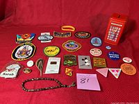 Photo of all patches, buttons, pins, magnets, and red telephone booth bank on red background