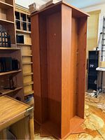 Side angled view of the tall wooden rotating CD/DVD shelves showing the vertical compartments and sturdy base.