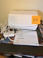 Closed Fujitsu ScanSnap scanner with USB cable, power adapter, and instruction manual placed in front.