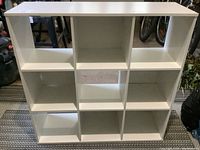 Front view of white cubical bookshelf with 9 equal square compartments arranged 3x3.