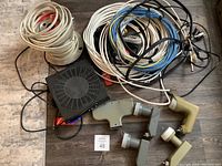 Lot displaying a black electronic set-top box, three satellite LNB devices, and various cables coiled and bundled.