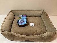 Beige rectangular dog bed showing front view with dog bowl and Hartz Flea and Tick Treatment placed inside