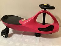 Photo of red and black Plasma Car ride-on toy showing profile and details