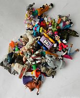 Top view of assorted Disney figures showing various characters including Goofy, Mickey, and others piled together.
