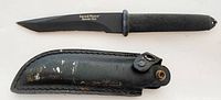 Photo of Smith & Wesson Special Ops fixed blade knife and black leather sheath on white background