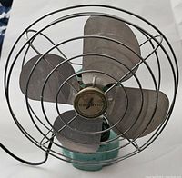 Front view showing the three metal blades with Eskimo logo hub and protective wire cage.