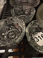 Close up of three small sherbet dishes showing starburst and floral cut patterns