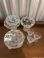 Full lot view showing two floral decorated pedestal bowls, one covered floral bowl, and three cut crystal wine glasses arranged on table.