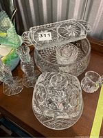 Photo of entire crystal collection showing butter dish with lid at front, two candle sticks to left, candy dish and other pieces in background