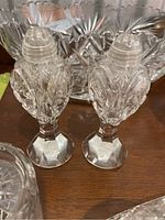 Close-up of crystal salt and pepper shakers with hexagonal bases and ornate cut pattern