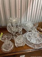 Overview of most Pinwheel crystal items on wooden surface, showing bowls, candlesticks, small serving pieces