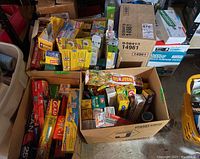 Photo of various boxes and packs of plastic wraps, tin foil, and garbage bags from brands including Glad, Saran, and Alcan arranged in cardboard boxes.