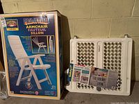 Photo shows boxed Primetime armchair in white with product details and folded Safety 1st security gate leaning against a wall.