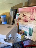 Photo showing boxed Fun-Damentals glassware sets in purple and blue-green, StarFrit decorating kit and multi-grater, vacuum bag sealer, and IKEA KVITTERA oval platter box