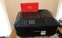 Black Canon all-in-one printer with a red Galada ink cartridge box on top