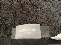 Close-up photo of gray towel label showing Land's End Home brand tag.