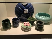 Full view of all seven ceramic items including vase, mugs, bowl, and covered containers.