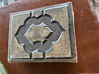 Top view of the closed Bible on a wooden surface showcasing the embossed leather cover design with floral and geometric patterns.
