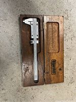 Micrometer in original wooden case, case open to show tool inside.