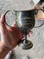 Front view showing donation inscription 'Charleston Lake Assoc. Donated by O J Banta' on silver plated cup