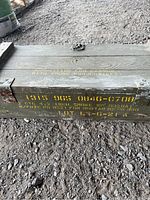 Side view showing yellow stenciled text with military specifications, including caliber and lot number.