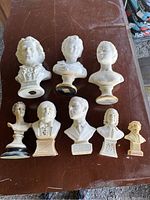 Top-down view of all 8 busts arranged on a table showing various sizes and styles.