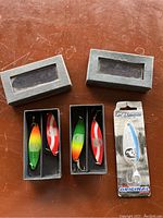 Four vintage fishing lures with two in black display boxes and one Len Thompson Original Series lure in original packaging from Nunavut Sustainable Development.