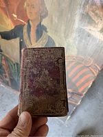 Front cover of the leather-bound Masonic Manual with gilt embossed square and compasses emblem.