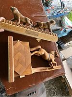 Photo showing both wooden carvings: horse on geometric base and two tigers on textured base.