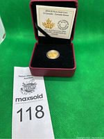 Burgundy hinged display case open, coin in capsule and certificate insert visible