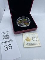 Overall view of coin in red presentation box with certificate and lot marker