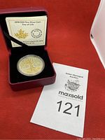 Photo of the 2018 $20 Tree of Life silver coin in protective capsule inside red display box, with certificate and auction lot card visible