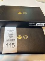 Closed black presentation box with gold Royal Canadian Mint logos and MaxSold lot label