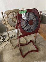 Maroon and beige box fans side by side on concrete floor