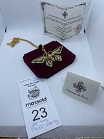 Full lot setup showing gold-tone butterfly pendant shaped like a butterfly with multicolored enamel and rhinestones on a 20 inch chain with certificate and presentation cards.