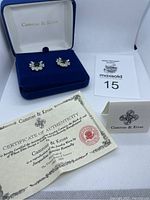 Earrings in blue velvet box with Certificate of Authenticity and a tag showing the lot number.