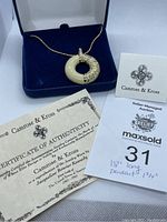 Necklace presented in navy blue box, includes certificate of authenticity and auction description card.