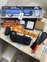 Overview of all items including boxed metal detector, handheld pinpointer, pouches, digging trowel