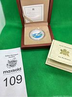 Rocky Mountain silver coin in wooden display box with certificate and booklet, lot tag in image.