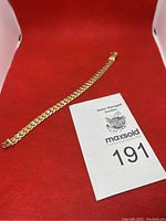 Full bracelet laid on red background with auction tag visible