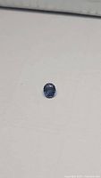 Angle view showcasing facets and color saturation of the cornflower blue sapphire on a white background.