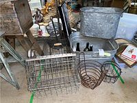 Overview of all metal and wire items including wash bins, wire baskets, and bottles on floor.