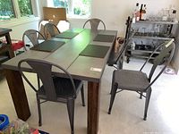 Set of 6 rustic industrial metal dining chairs arranged around a dining table in a room, showing overall style and condition