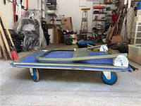 Side view of the Olympia folding trolley showing platform, wheels and folded handle.