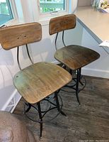 Two bar stools side by side from front view showing seats and backs