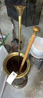 Long narrow brass hunting horn placed inside umbrella stand, flared bell end visible
