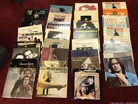 Photo showing a laid out group of vinyl records including Johnny Mathis, Dionne Warwick, Creedence Clearwater Revival, Simon & Garfunkel, Joe Cocker, Bob Dylan and others stacked in rows.